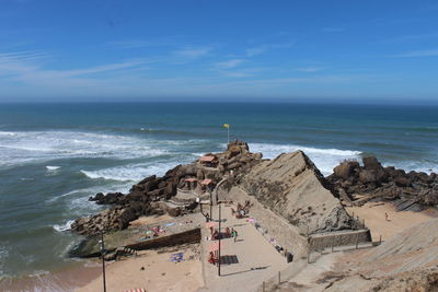 Scenic view of rock formation in sea against blue sky