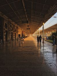 Rear view of people walking in corridor of building