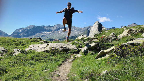 Rear view of man jumping on mountain