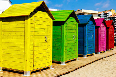 Multi colored umbrellas on beach against buildings