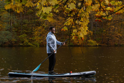 Rear view of man kayaking in lake
