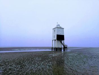 Lifeguard hut on beach against sky