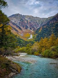 Scenic view of river amidst mountains against sky
