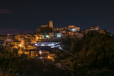 Illuminated cityscape against sky at night