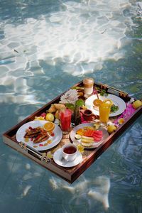 High angle view of breakfast on table at swimming pool