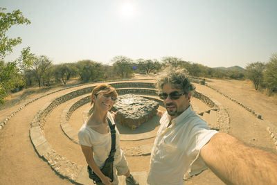 Couple taking selfie while standing at hoba meteorite