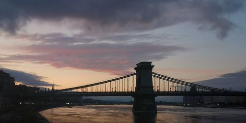 Bridge over river against cloudy sky