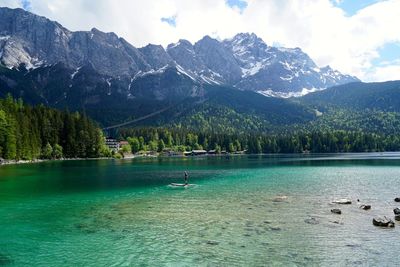 Scenic view of lake by mountains against sky