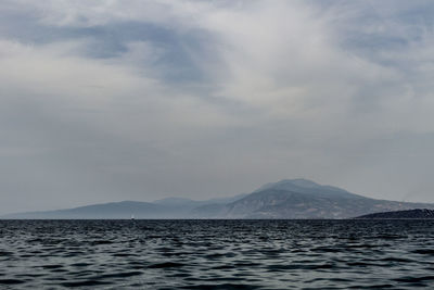 View of calm sea against mountain range