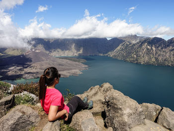 Woman looking at sea against mountains