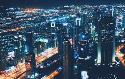 High angle view of illuminated street amidst buildings at night