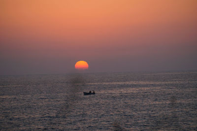 Scenic view of sea against orange sky