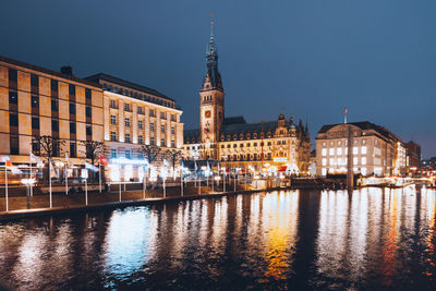 Hamburg town hall at night with reflections of the alster