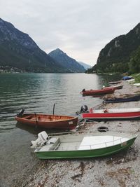 Boats moored at lake against sky