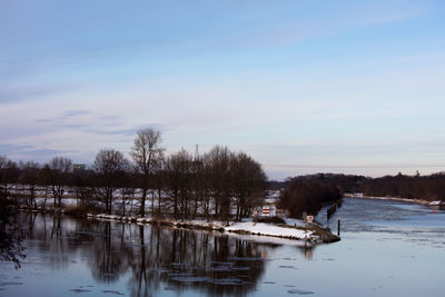 Scenic view of lake against sky during winter