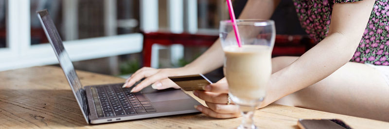 Midsection of woman using laptop on table