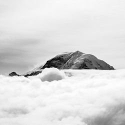 Snow covered mountain peak surrounded by clouds