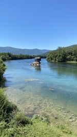 Scenic view of lake against clear blue sky