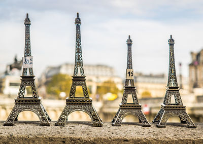 Four miniature eiffel tower souvenirs on retaining wall