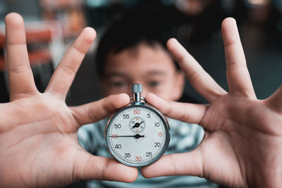 Close-up of boy holding pocket watch