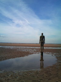 Rear view of man and woman walking on beach