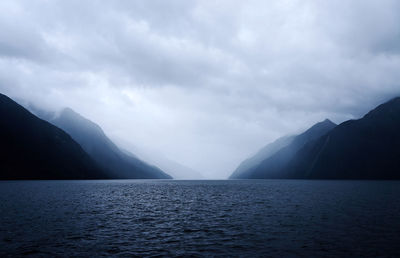 Scenic view of sea and mountains against sky