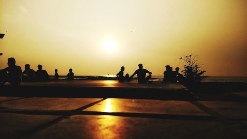 Silhouette people against sky during sunset