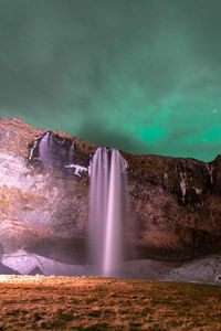 Northen light at seljalandsfoss waterfall, iceland.