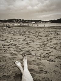 Low section of person relaxing on beach