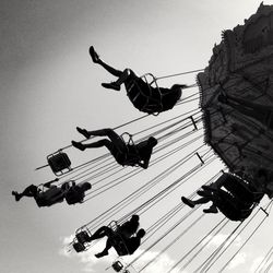 Low angle view of people enjoying chain swing ride