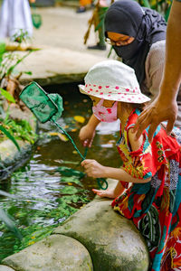 Children are trying to catch fish at the small water tunnel. barefoot