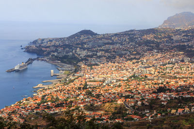 High angle view of townscape by sea against sky