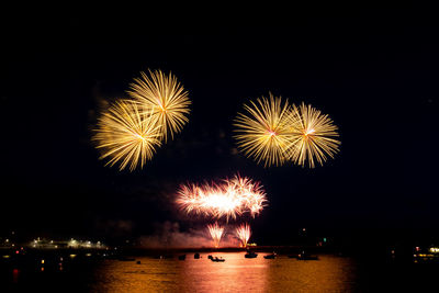 Firework display over river at night