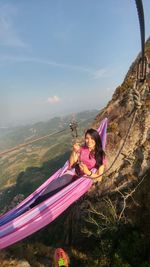 Portrait of smiling girl on mountain against sky