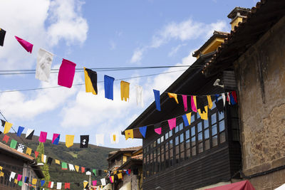 Low angle view of flags hanging against sky