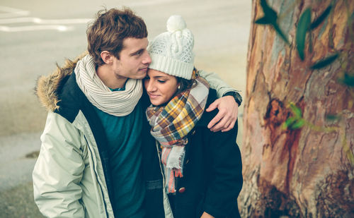 Couple embracing while wearing warm clothing in city