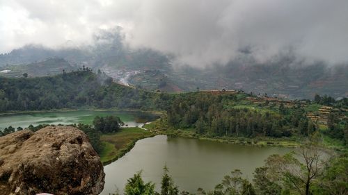 Scenic view of river against cloudy sky