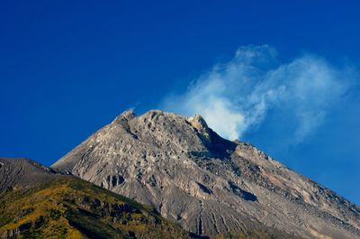 Low angle view of mountain against blue sky