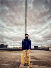 Young man standing against sky