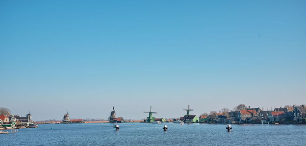 Sailboats in sea against clear blue sky