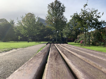 Surface level of railroad tracks in park against sky