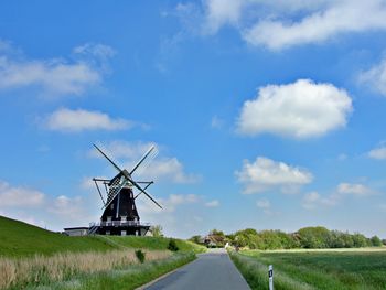 Traditional windmill on field against sky