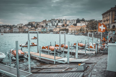 Boats moored in river with buildings in background