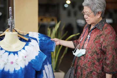 Midsection of woman holding umbrella while standing in store