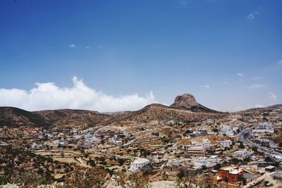 Town by mountains against sky