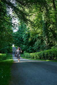 Rear view of woman walking on road