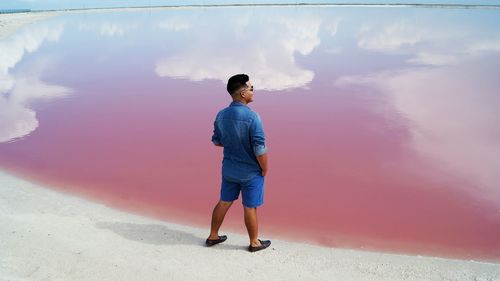 High angle view of man standing against calm lake