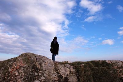 Rear view of man standing on rock