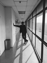 Rear view of man walking in corridor of building