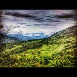 Scenic view of mountains against cloudy sky